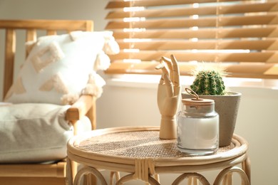 Stylish table with decor and houseplant in light room. Interior design