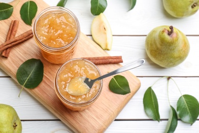 Delicious pear jam and fresh fruits on white wooden table, flat lay