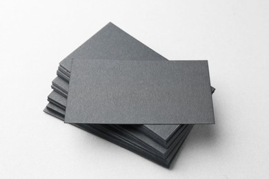 Blank black business cards on white table, closeup. Mockup for design