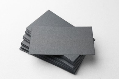 Photo of Blank black business cards on white table, closeup. Mockup for design