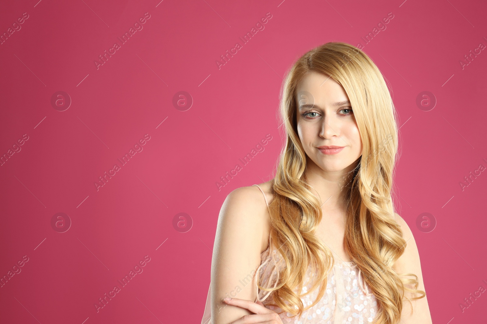 Photo of Portrait of beautiful young woman with dyed long hair on pink background. Space for text