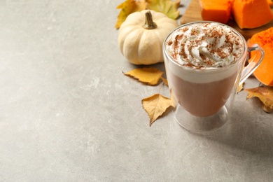 Photo of Delicious pumpkin latte on grey table. Space for text
