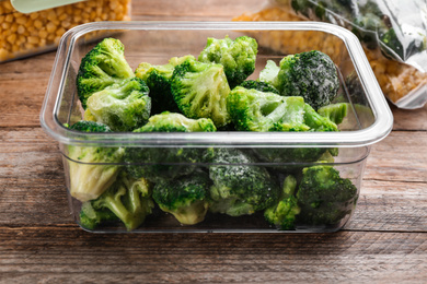 Frozen broccoli on wooden table, closeup. Vegetable preservation