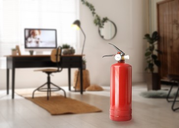 Image of Fire extinguisher on floor in office. Space for text