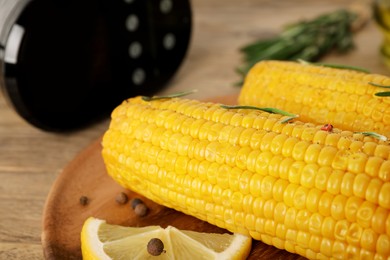 Photo of Delicious boiled corn served on wooden table, closeup. Sous vide cooking