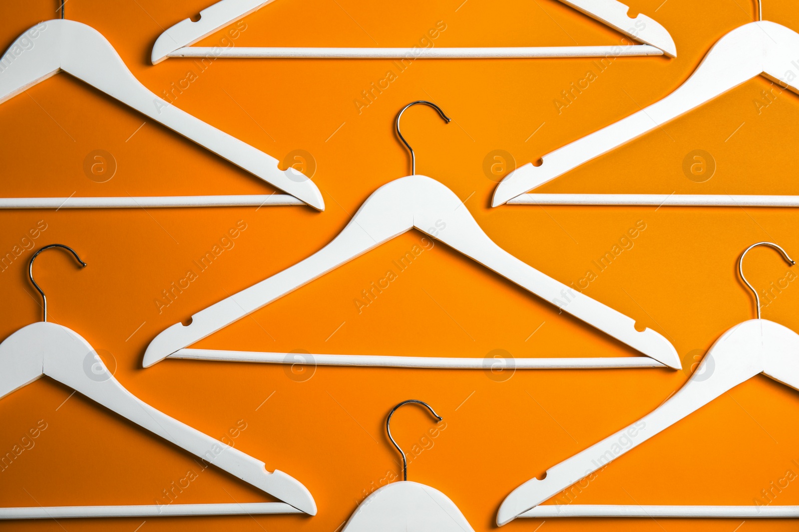 Photo of Flat lay composition with empty hangers on color background