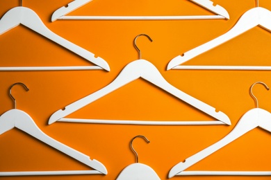 Photo of Flat lay composition with empty hangers on color background