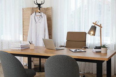 Photo of Modern medical office interior with doctor's workplace and chairs