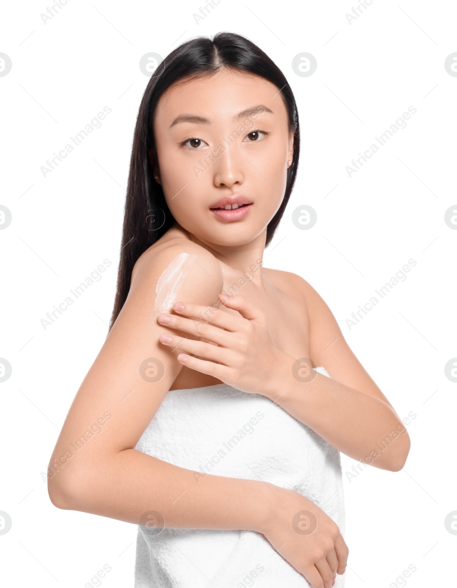 Photo of Beautiful young Asian woman applying body cream onto shoulder on white background