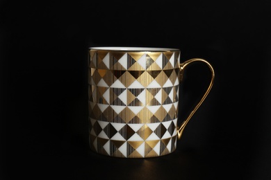 Cup with gold pattern on black background