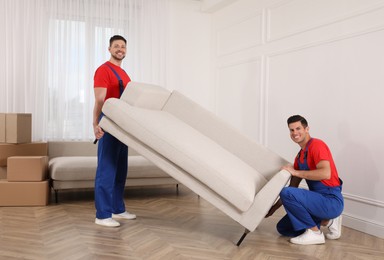 Photo of Professional movers carrying sofa in new house