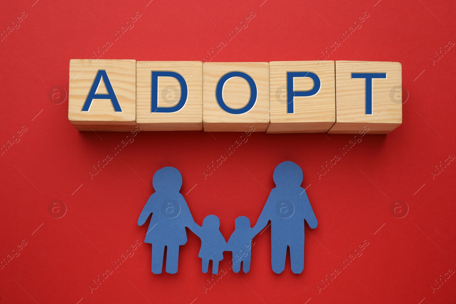 Photo of Family figure and word Adopt made of cubes on red background, flat lay