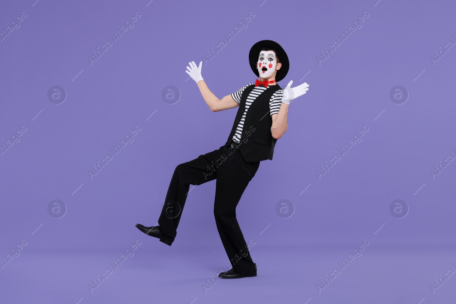 Photo of Mime artist making shocked face on purple background