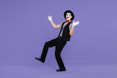 Photo of Mime artist making shocked face on purple background