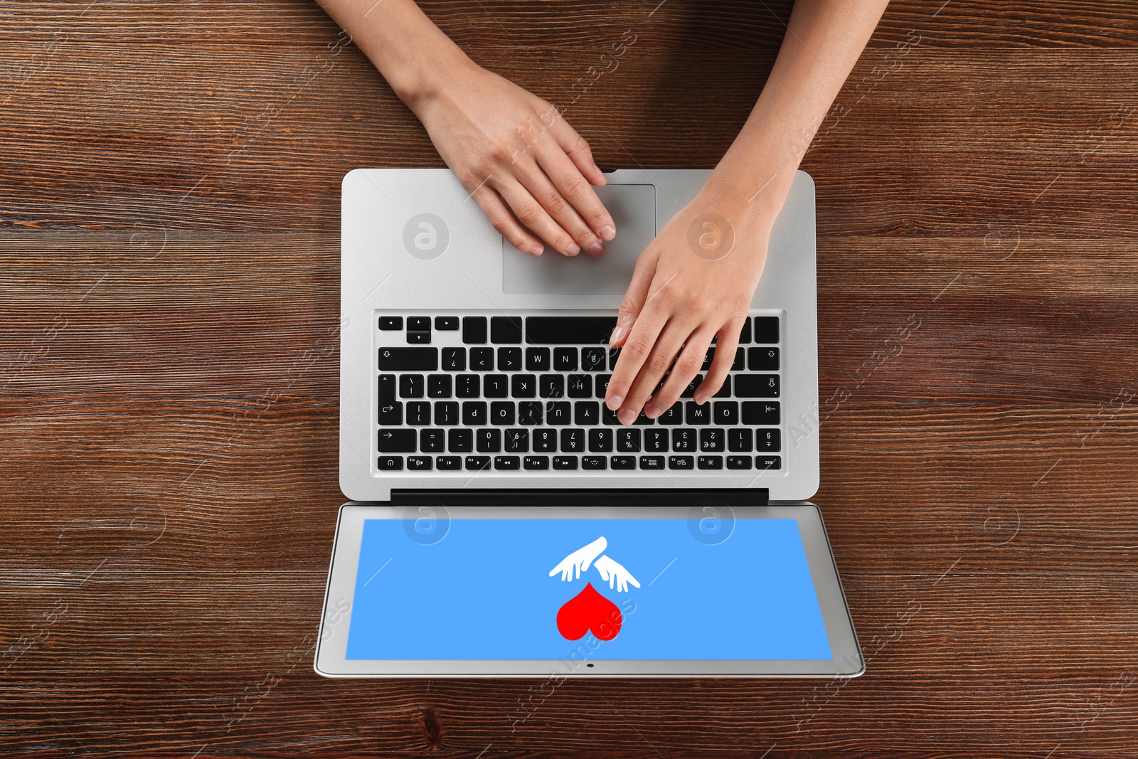 Image of Donations concept. Woman with laptop at wooden table, top view