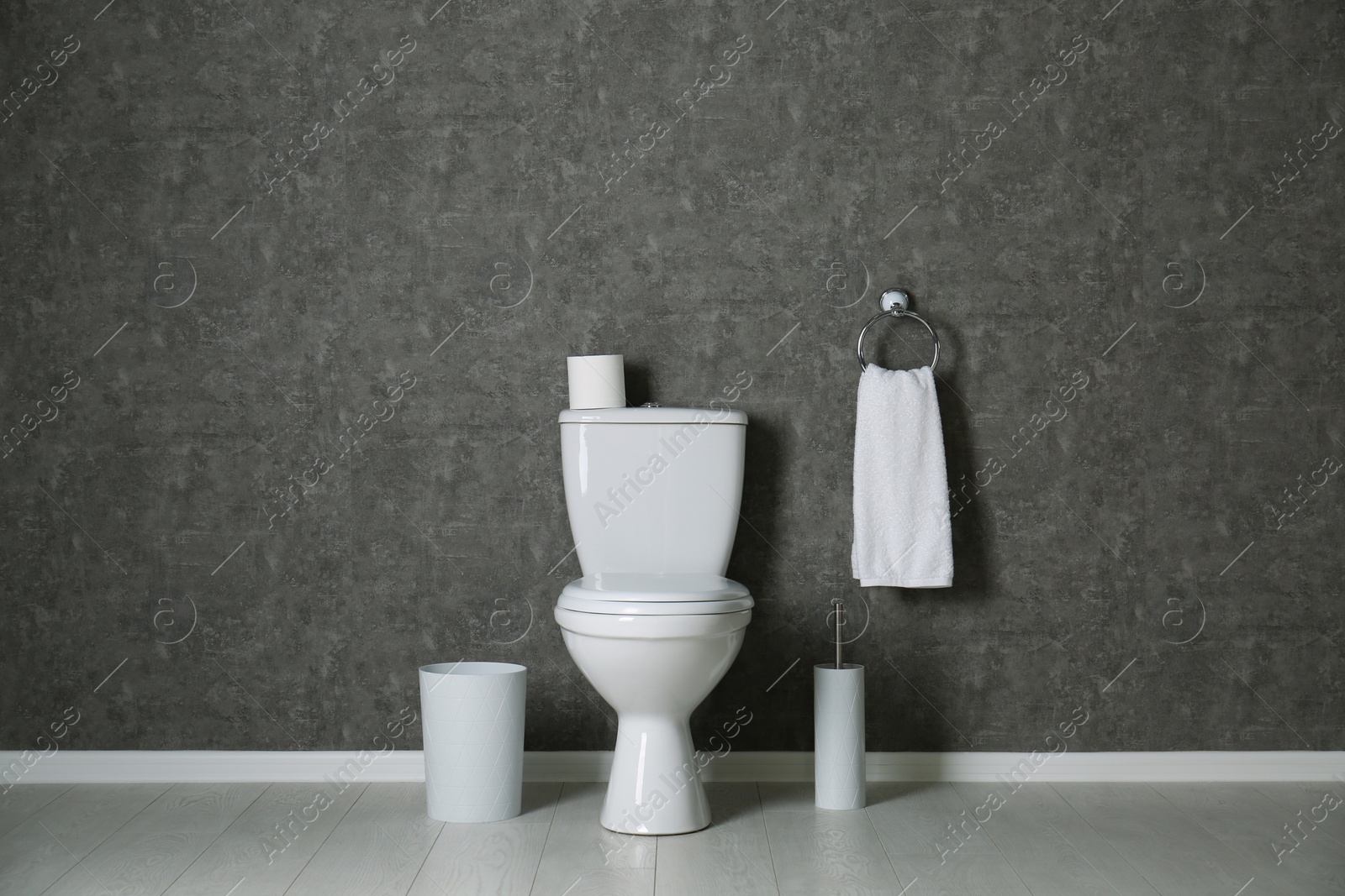 Photo of Simple bathroom interior with new toilet bowl near grey wall