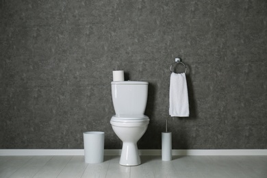 Simple bathroom interior with new toilet bowl near grey wall