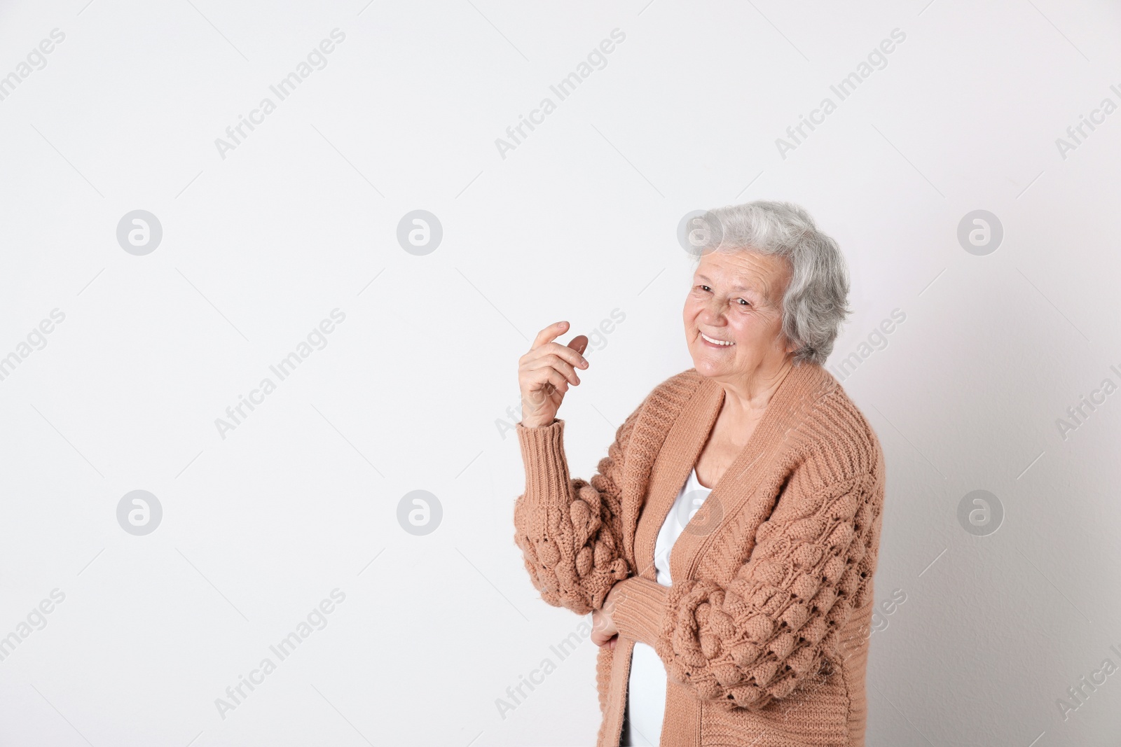 Photo of Portrait of grandmother in stylish clothes on light background, space for text