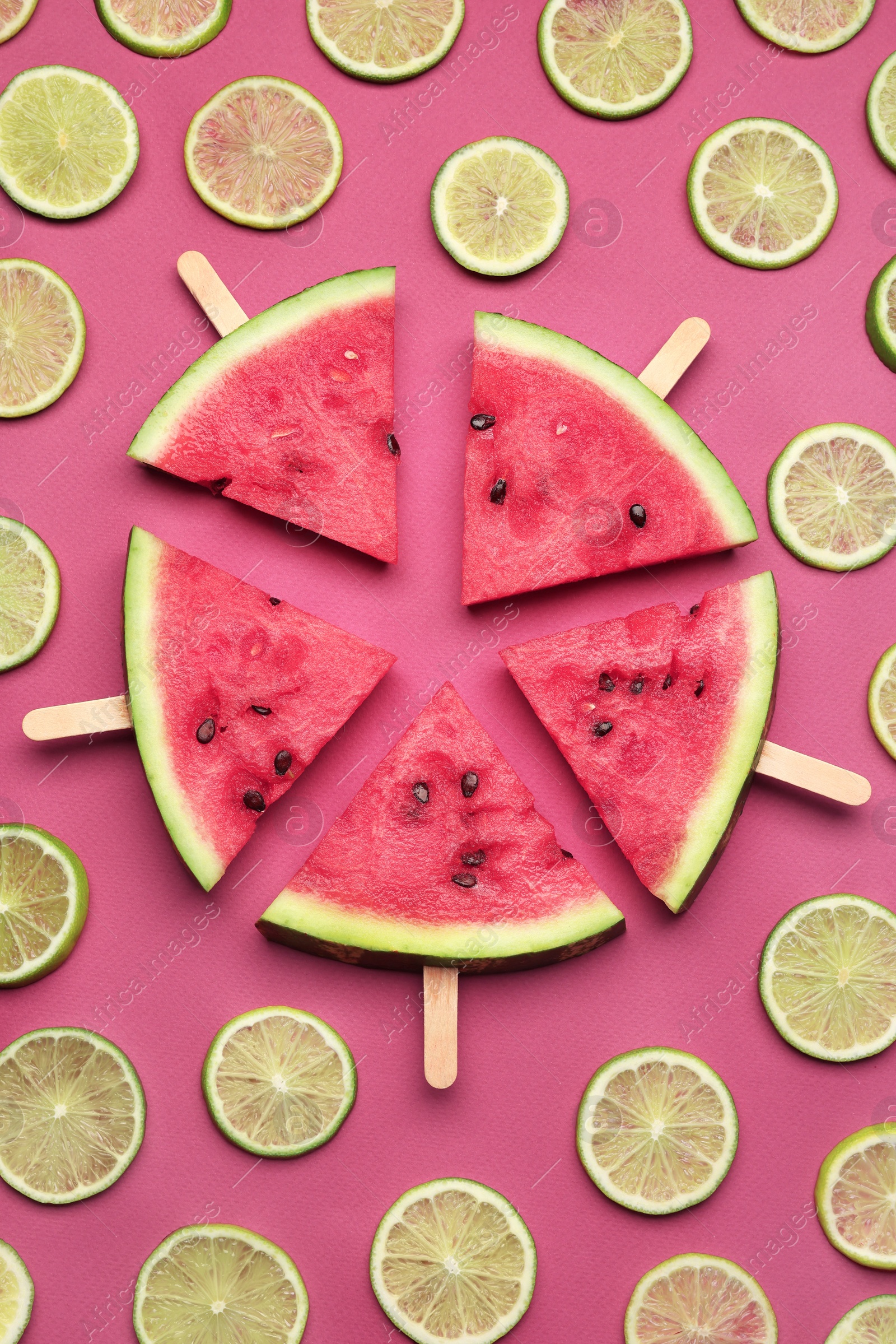 Photo of Tasty sliced watermelon and limes on red background, flat lay