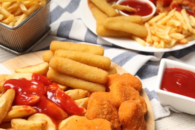 Photo of Different snacks served with tasty ketchup on table, closeup
