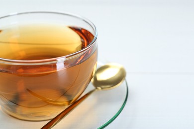 Glass cup of tea on white table, closeup