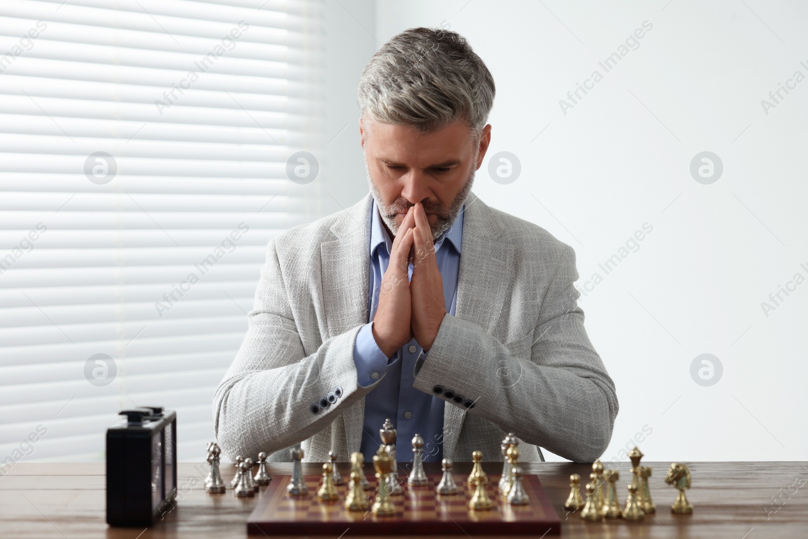 Photo of Man playing chess during tournament at table indoors