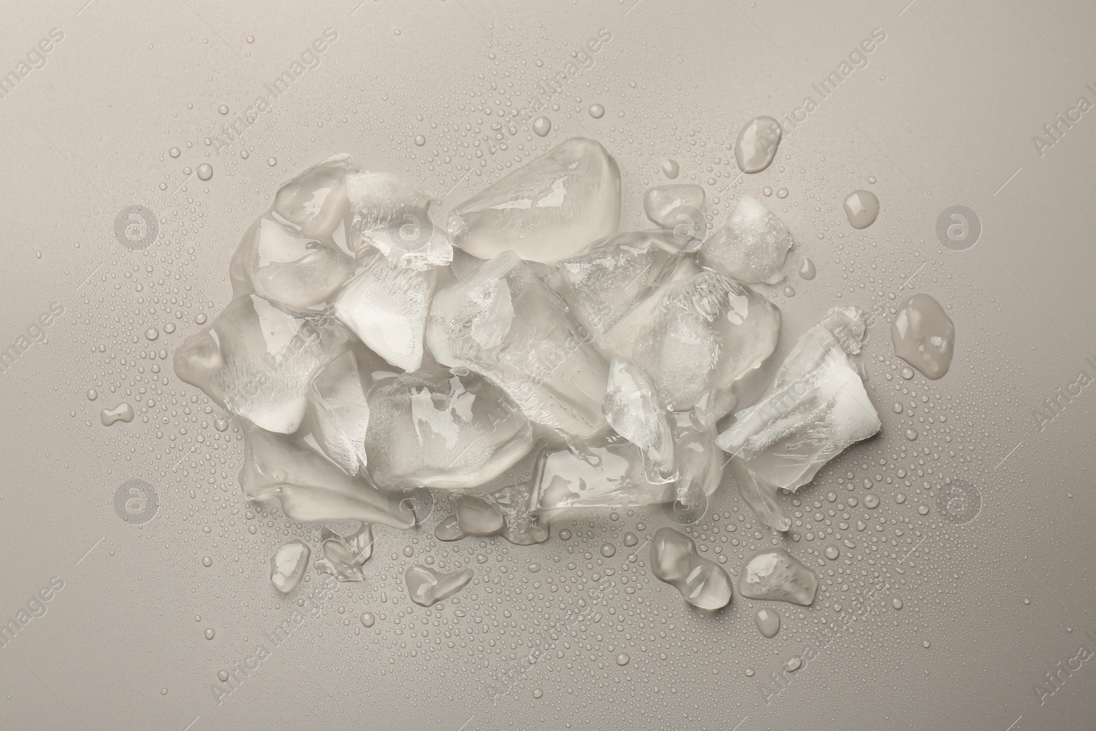 Photo of Pieces of crushed ice on grey background, top view