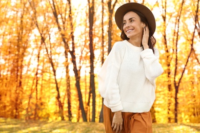 Beautiful happy woman wearing hat in park. Autumn walk