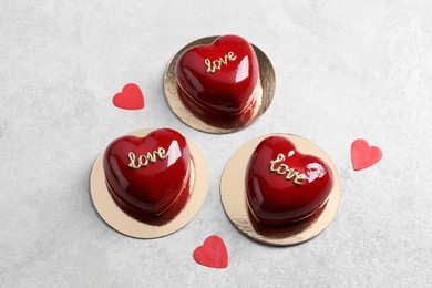 Photo of St. Valentine's Day. Delicious heart shaped cakes on light table, flat lay