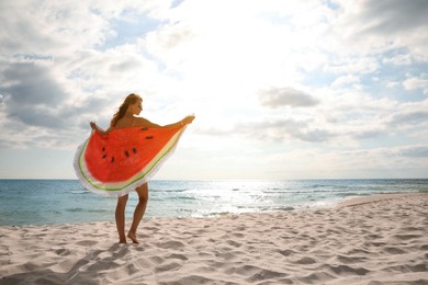 Photo of Beautiful woman with bright beach towel on sunlit seashore