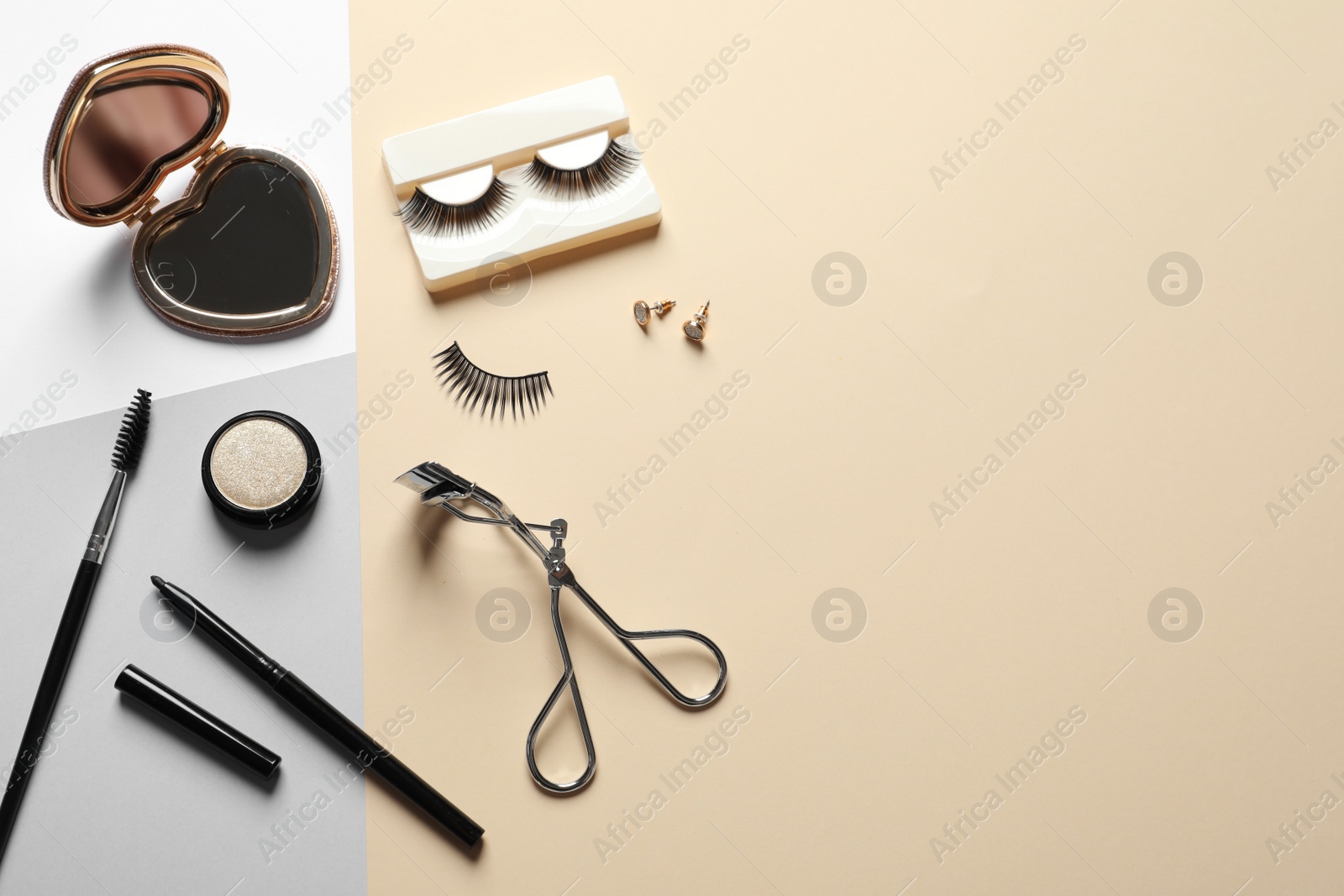 Photo of Flat lay composition with false eyelashes and other makeup products on color background, space for text