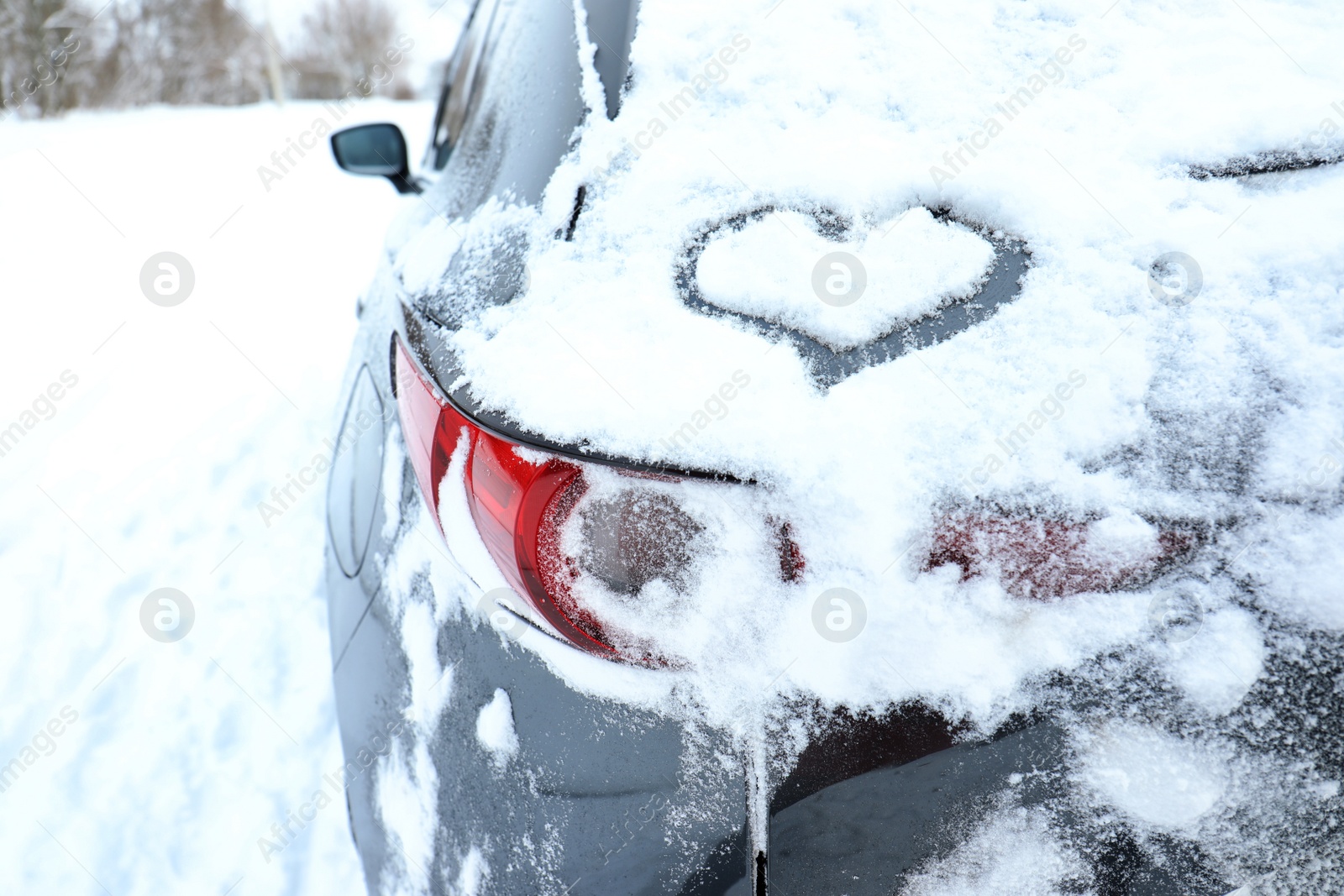 Photo of Heart drawn on car covered with snow outdoors, closeup