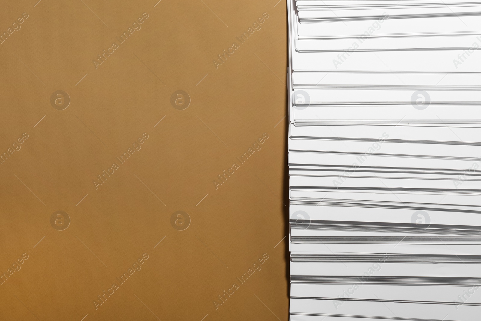 Photo of White paper sheets on brown background, flat lay. Space for text