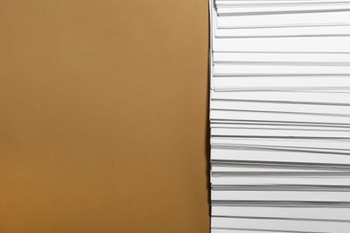 Photo of White paper sheets on brown background, flat lay. Space for text