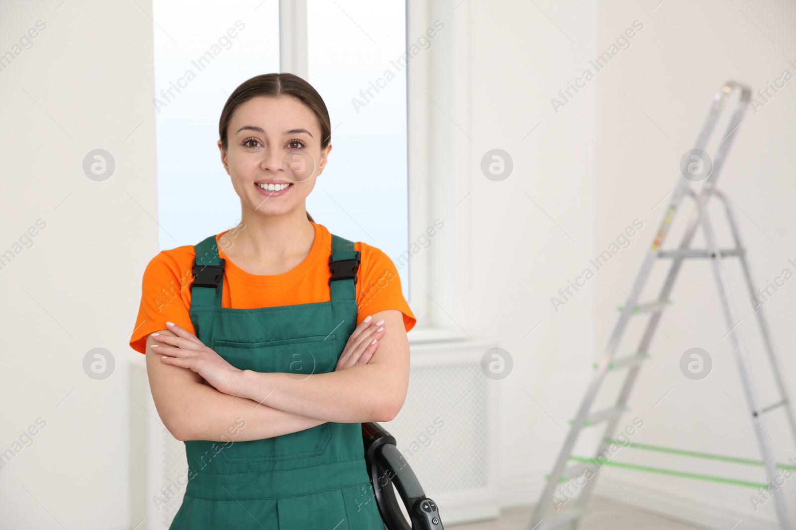 Photo of Professional young janitor in uniform indoors. Cleaning service