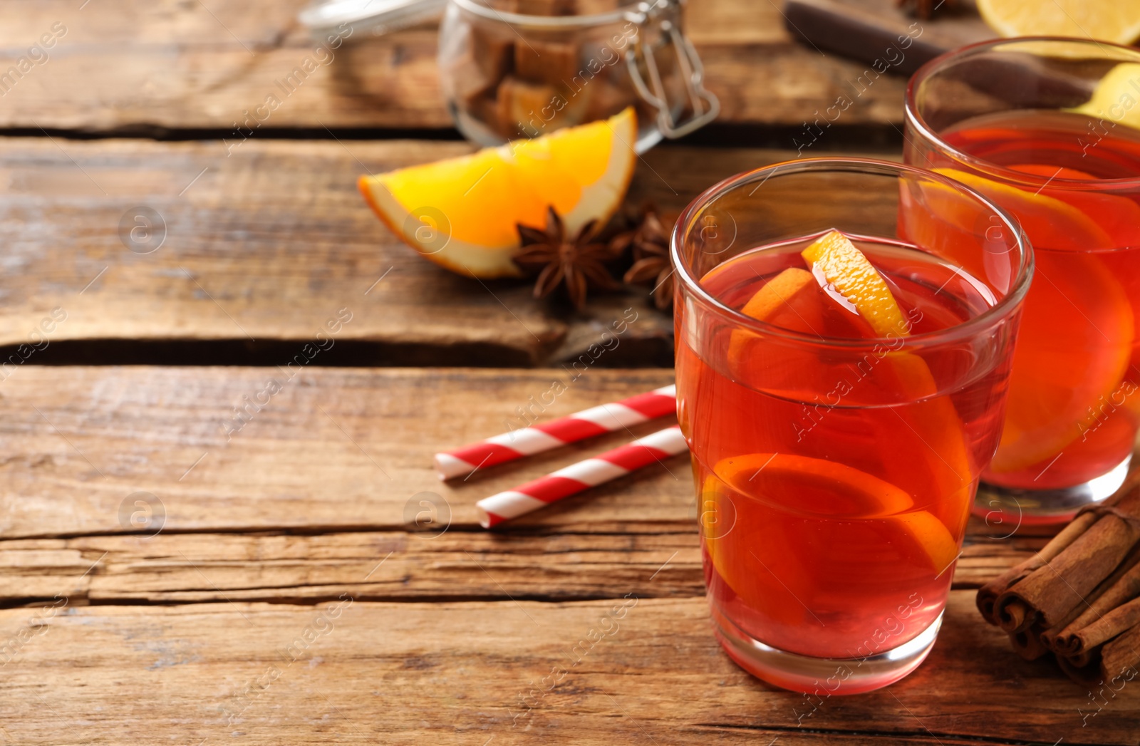 Photo of Aromatic punch drink and ingredients on wooden table. Space for text