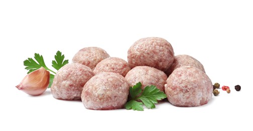 Photo of Many fresh raw meatballs with parsley and spices on white background