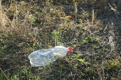 Photo of Used plastic bottle outdoors. Environmental pollution concept