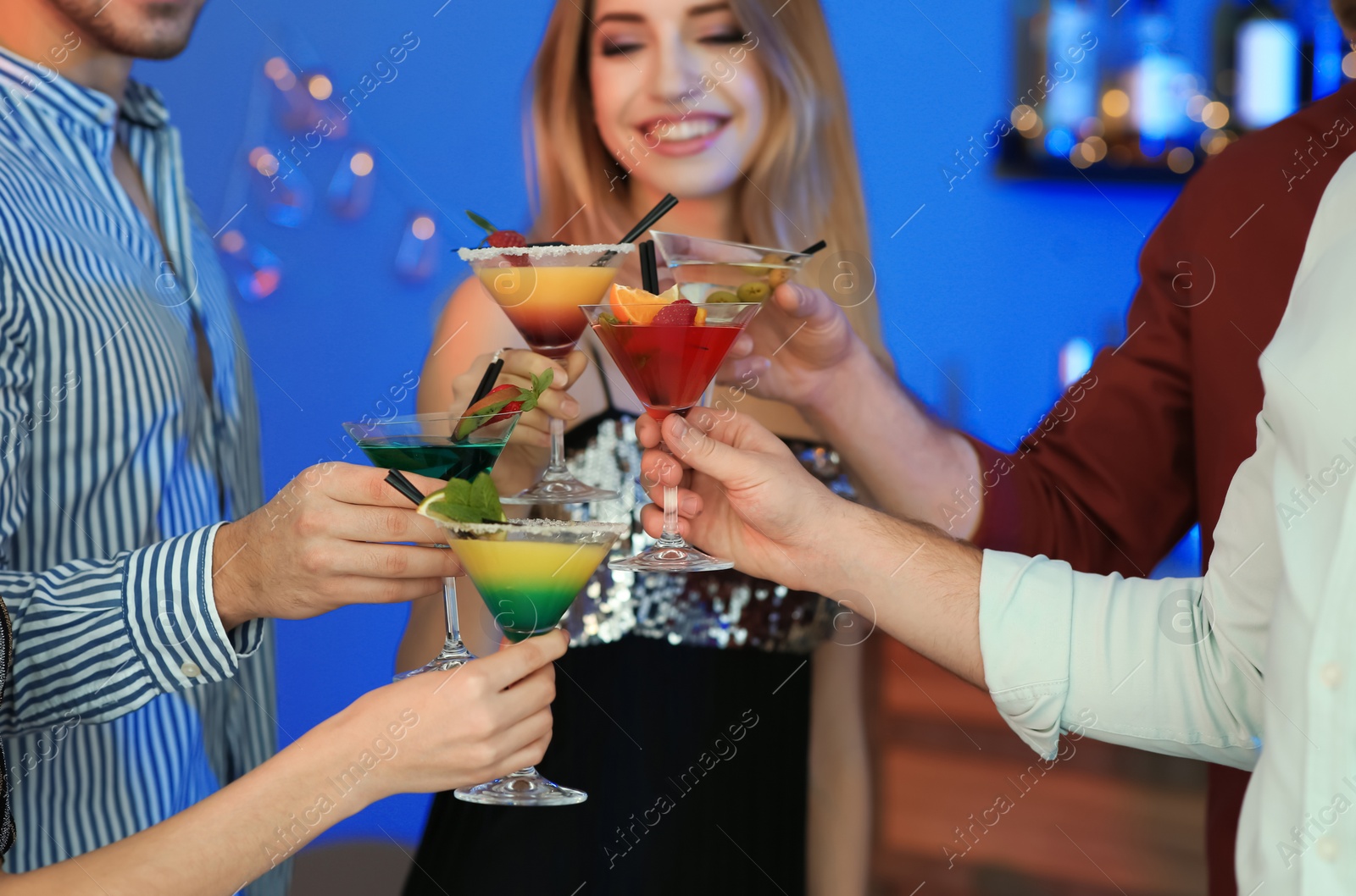 Photo of Group of young people holding martini cocktails at party, closeup