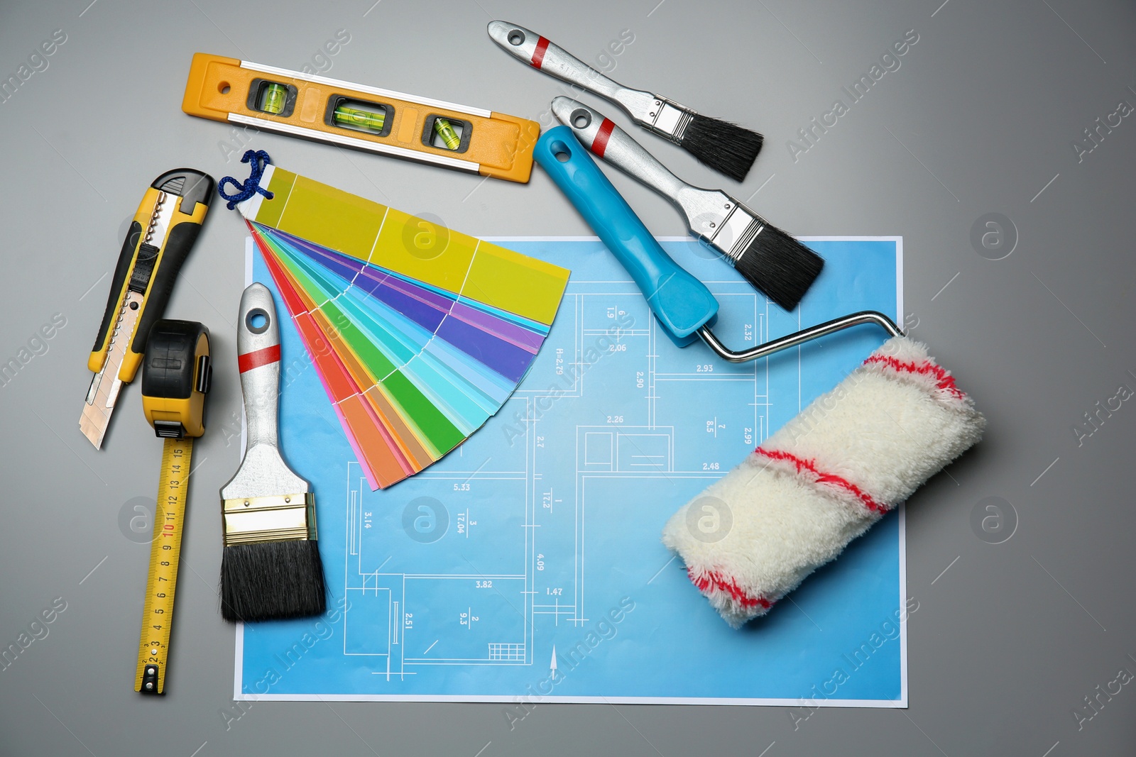 Photo of Set of decorator's tools and project drawing on grey background