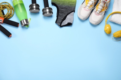 Sportswear and equipment on light blue background, flat lay. Space for text