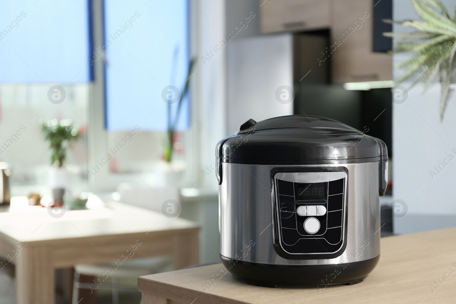 Photo of Modern multi cooker on table in kitchen. Space for text