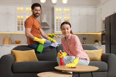 Photo of Spring cleaning. Lovely couple tidying up living room together