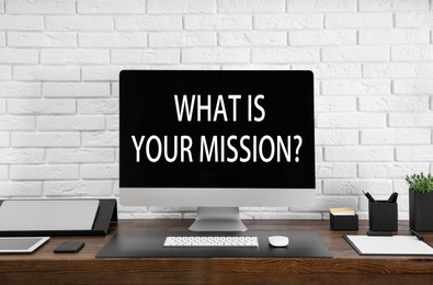 Modern computer with question WHAT IS YOUR MISSION? on screen indoors 