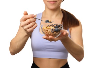 Woman eating tasty granola with fresh berries on white background, closeup