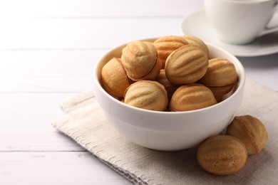 Photo of Delicious nut shaped cookies with boiled condensed milk on white wooden table