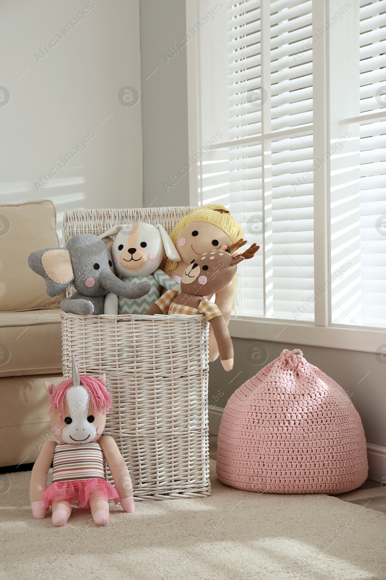 Photo of Funny stuffed toys and basket in children's room. Interior decor