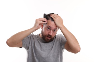 Dandruff problem. Man with comb examining his hair and scalp on white background