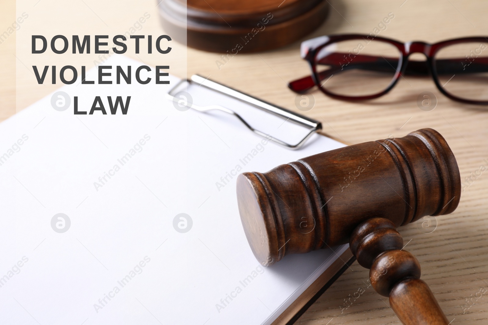 Image of Clipboard and gavel on wooden table. Domestic violence law concept