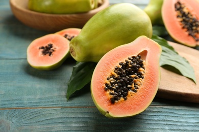 Photo of Fresh ripe papaya fruits on wooden table. Space for text